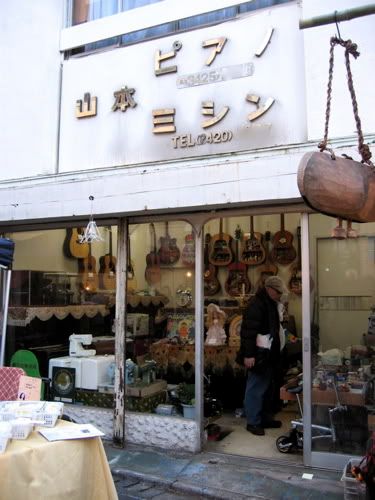 古いモルタルの店頭にめっきのはがれかけた「山本ピアノ、ミシン」の文字